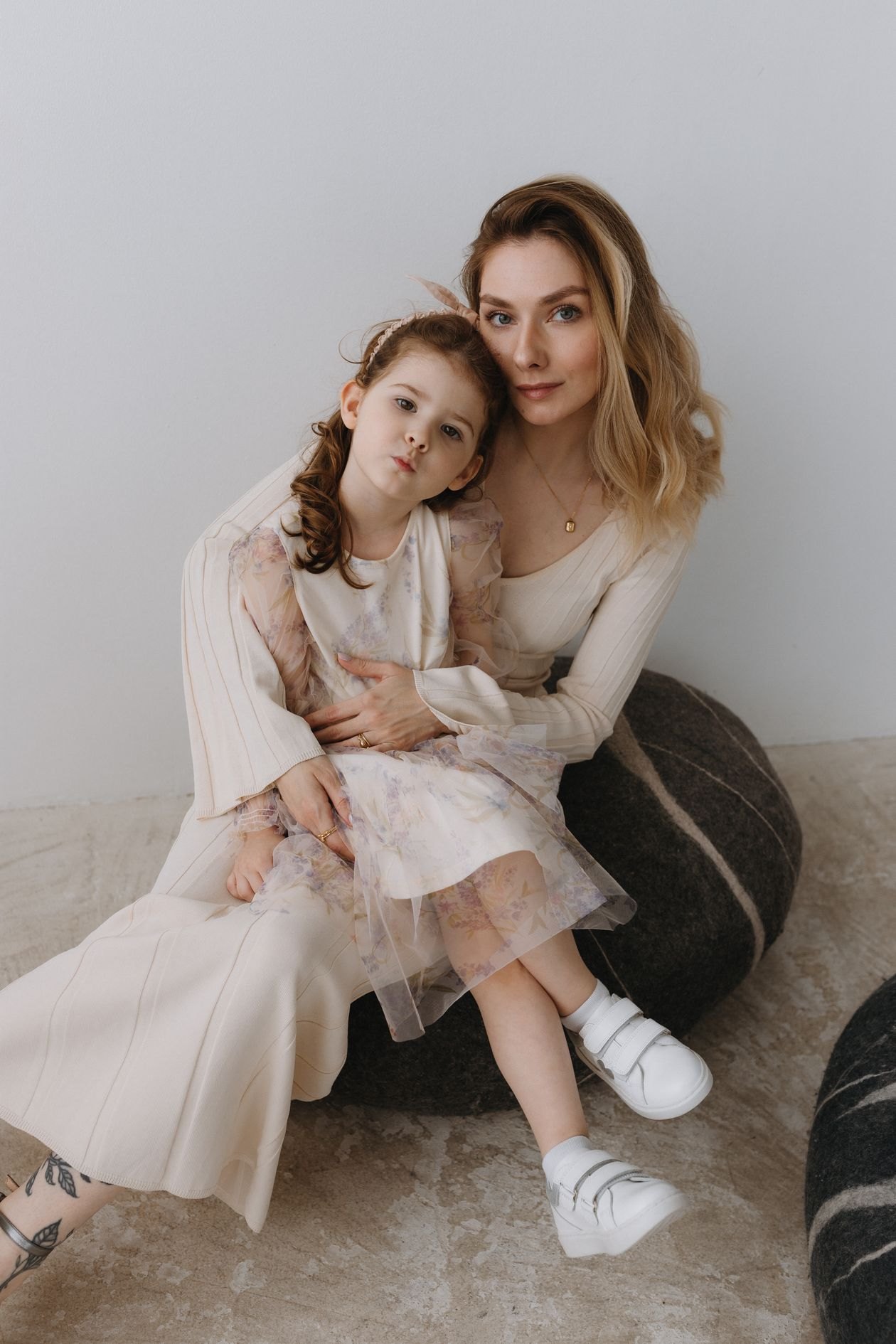 Mother and daughter seated together in elegant dresses